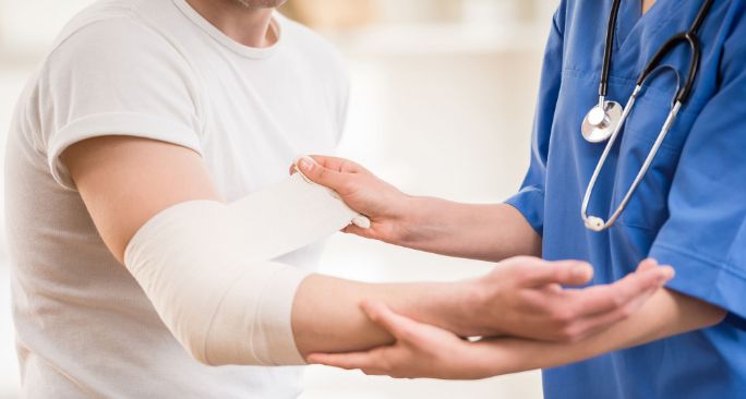 怪我をした腕に包帯を巻いている医療従事者